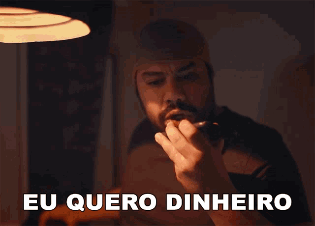 a man with a beard is talking on a cell phone with the words eu quero dinheiro below him
