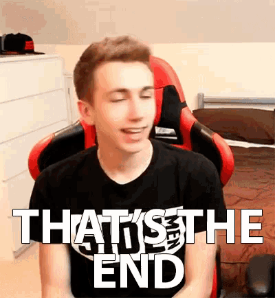 a young man is sitting in a gaming chair with his eyes closed and the words that 's the end written on his shirt .