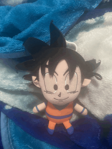 a stuffed cartoon character laying on a blue and white blanket