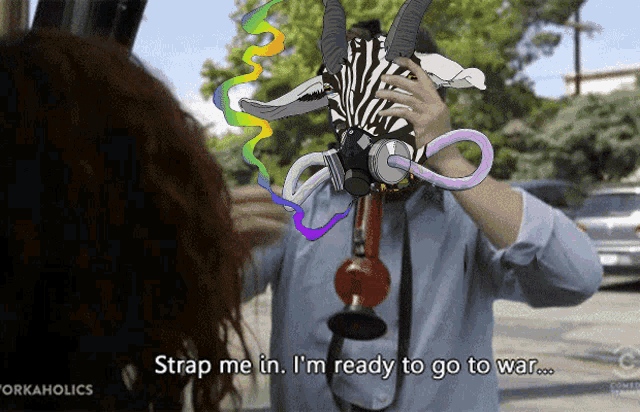 a man with a zebra mask on his head says strap me in i 'm ready to go to war ..