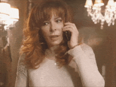 a woman with red hair is talking on a phone