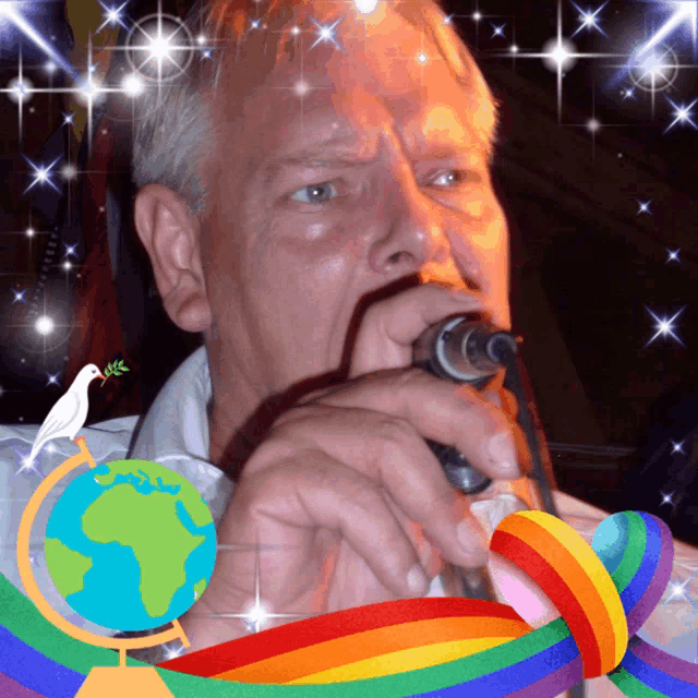 a man singing into a microphone with a globe and rainbow behind him