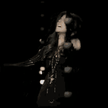 a woman is screaming and saying `` yeah yeah '' in a black background .
