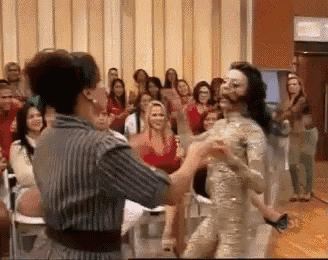a woman in a mummy costume is dancing in front of a crowd .