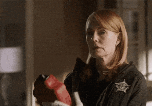 a woman in a black jacket has a sheriff 's badge on her chest