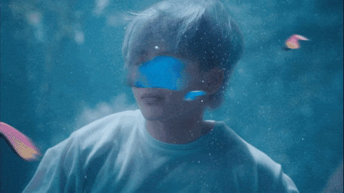 a person in a white shirt is swimming underwater