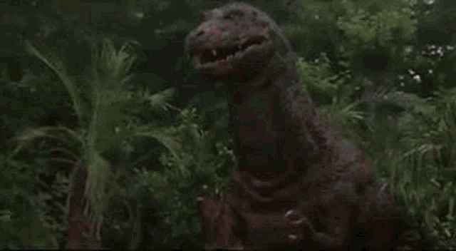 a dinosaur with blood coming out of its mouth is standing in a forest .