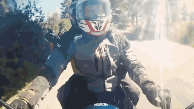 a person riding a motorcycle with a helmet that has the letter v on it