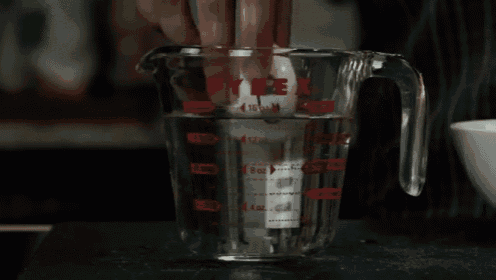 a pyrex measuring cup filled with liquid and a timer