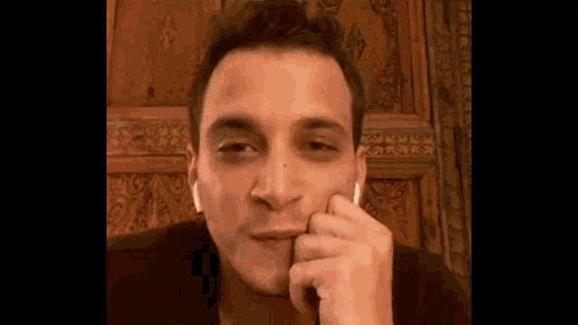 a man with a black eye is holding his hand to his face .