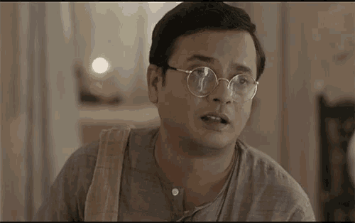 a man wearing glasses and a towel around his shoulder