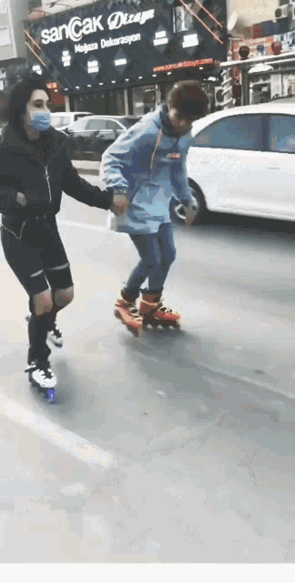 a woman wearing a mask is helping a boy roller skate down the street