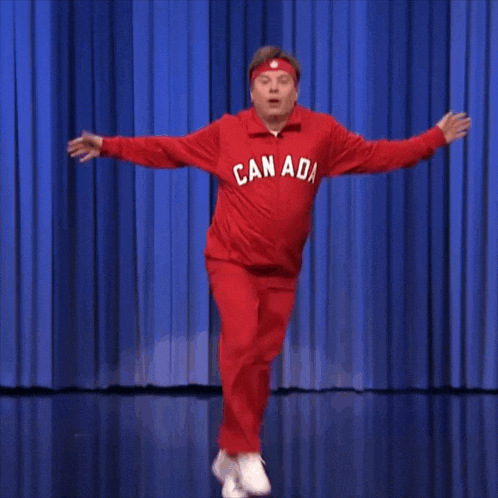 a man wearing a red canada shirt is dancing on stage