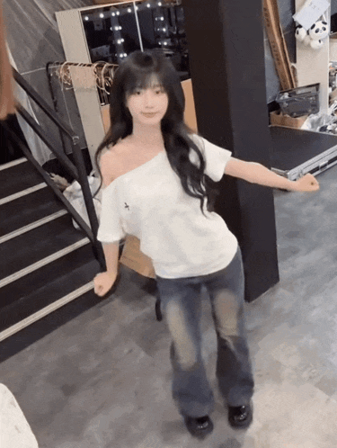 a woman in a white off the shoulder shirt is dancing in a room