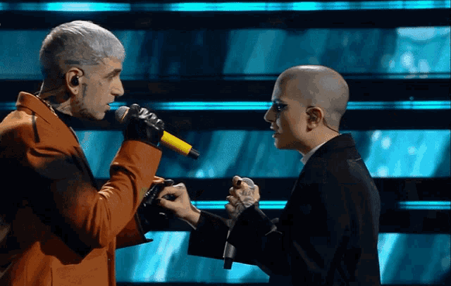 a man singing into a microphone next to a woman