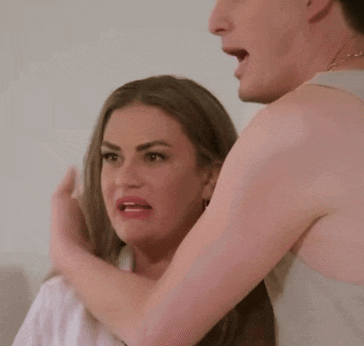 a man and a woman are standing next to each other and the woman is making a surprised face .
