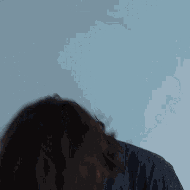 a blurry picture of a woman covering her face with her hand