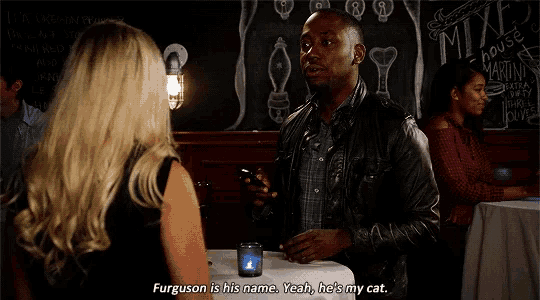 a man in a leather jacket is talking to a woman in front of a blackboard that says mixe