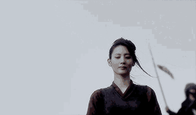 a woman in a costume is holding a sword in her hand .