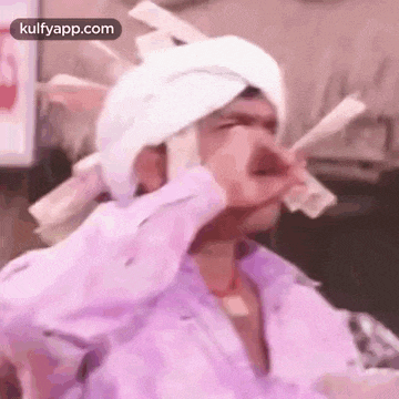 a man with a bandage on his head is holding a bunch of money in his hand .