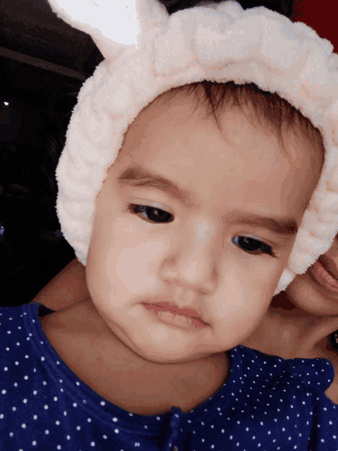 a baby girl wearing a headband with bunny ears