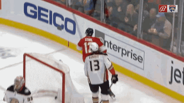 a hockey player with the number 13 on his jersey stands on the ice