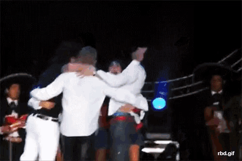 a group of people hugging each other on a stage with rbd.gif in the corner