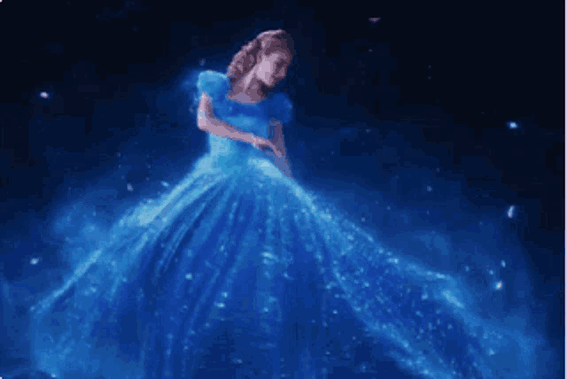 a woman in a blue dress dancing in the dark
