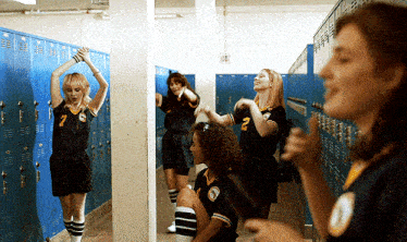 a girl with the number 7 on her shirt is standing in a locker room