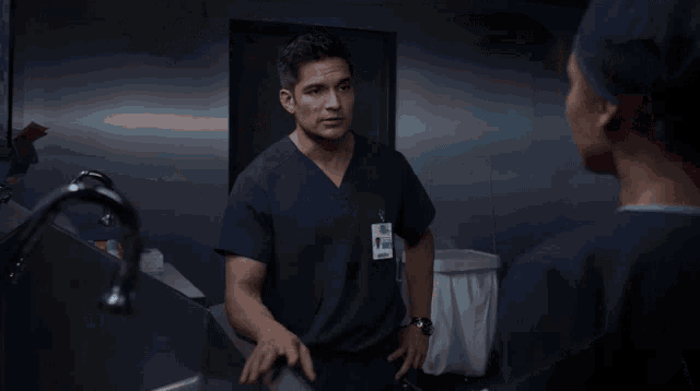 a woman in a scrub cap looks at a man