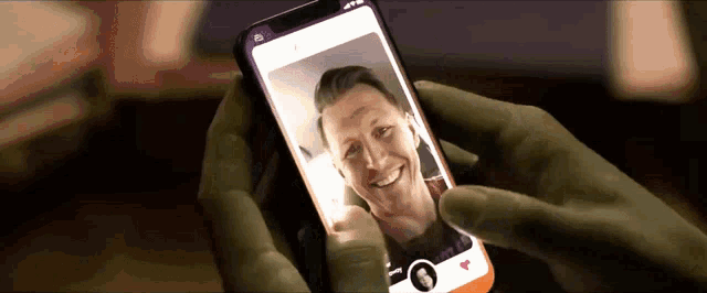 a person holding a phone with a picture of a man on it