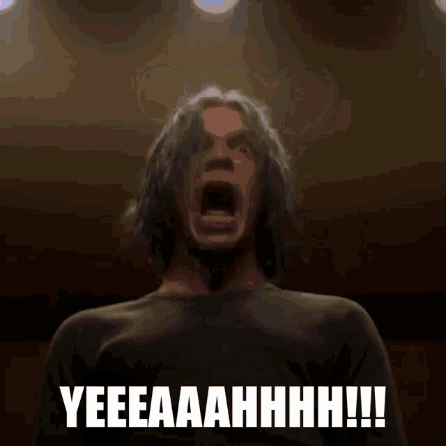 a man is standing in front of a television with the words yeeeaaahhhh !!! written below him