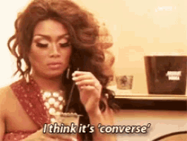 a drag queen says i think it 's converse while holding a drink