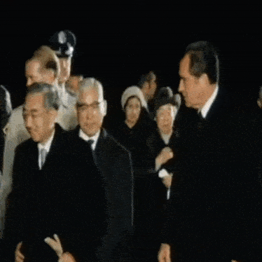 a man in a suit and tie is standing in a crowd of people