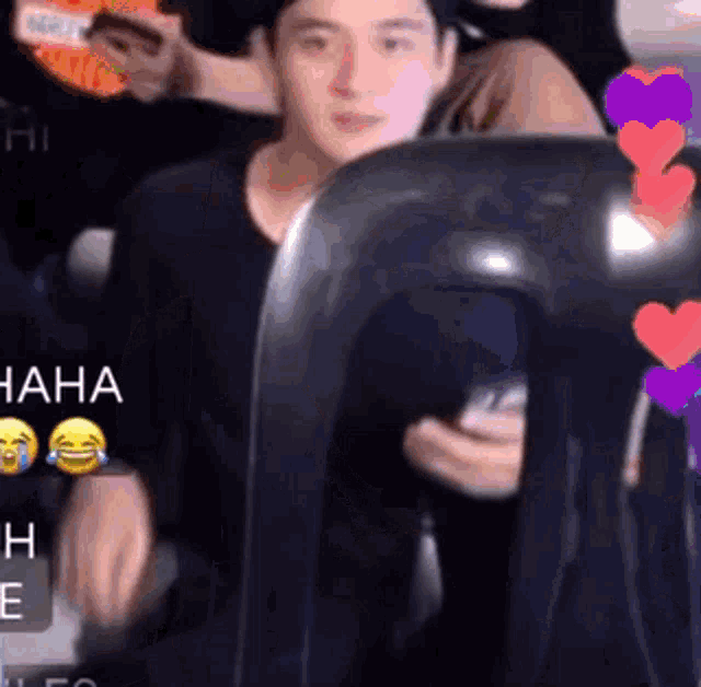 a man in a black shirt is sitting in a chair with hearts on it .