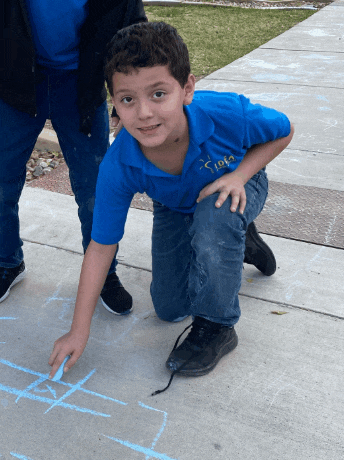 a boy wearing a blue shirt that says ' iota ' on it