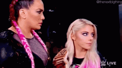two women are standing next to each other on a stage .