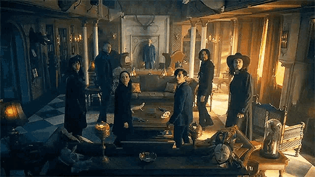 a group of people are standing in a living room with a fireplace .