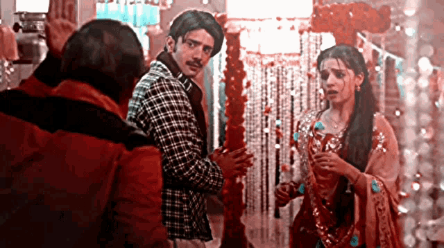 a man and woman standing next to each other in a room