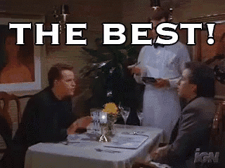 two men are sitting at a table in a restaurant with the words the best written on the table .
