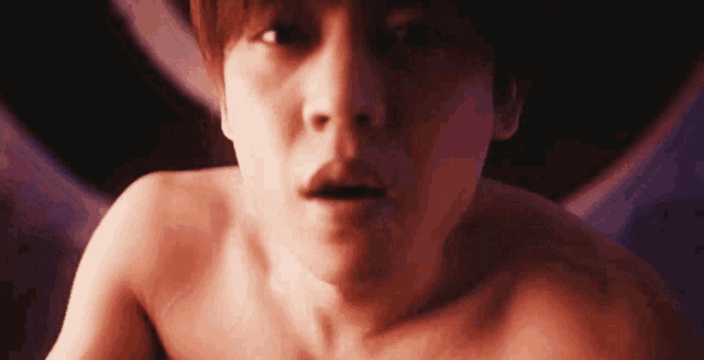 a man without a shirt is looking at the camera with a surprised look on his face
