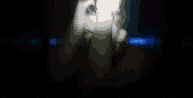 a blurry image of a person covering their face in a dark room .