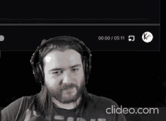 a man wearing headphones has his fist in the air in front of a screen that says cleido.com