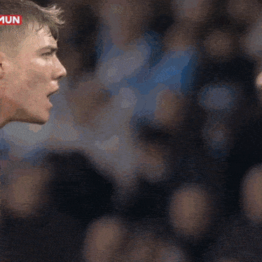 a man in a blue shirt is yelling at another man in a red shirt with the word mun on the bottom
