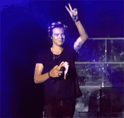 a man giving a peace sign while holding a microphone