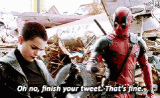 a man in a deadpool costume is standing next to another man in a destroyed building .