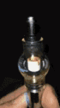 a person is holding a glass bottle with a light inside of it .