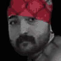 a man with a beard and mustache is wearing a red hat .