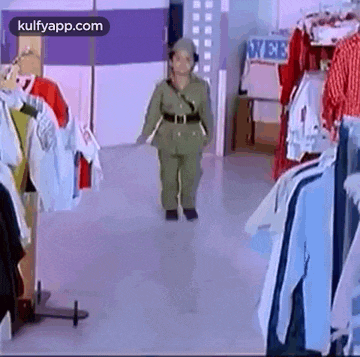 a little boy in a military uniform is walking in a clothing store .