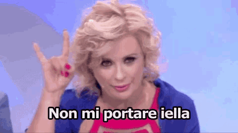 a woman is making a devil horns sign with her hand and the words non mi portare iella are below her